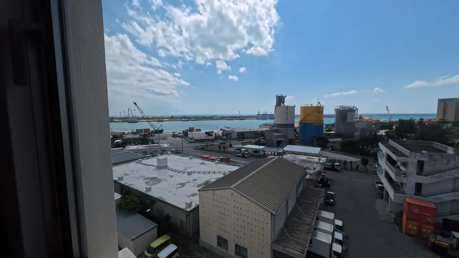 部屋の窓から見た石垣の街と海
